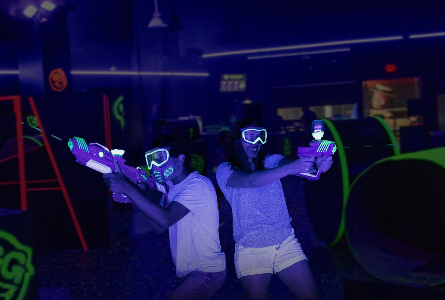 2 people aiming their gel blasters inside the warzone arena at Toxic Blast